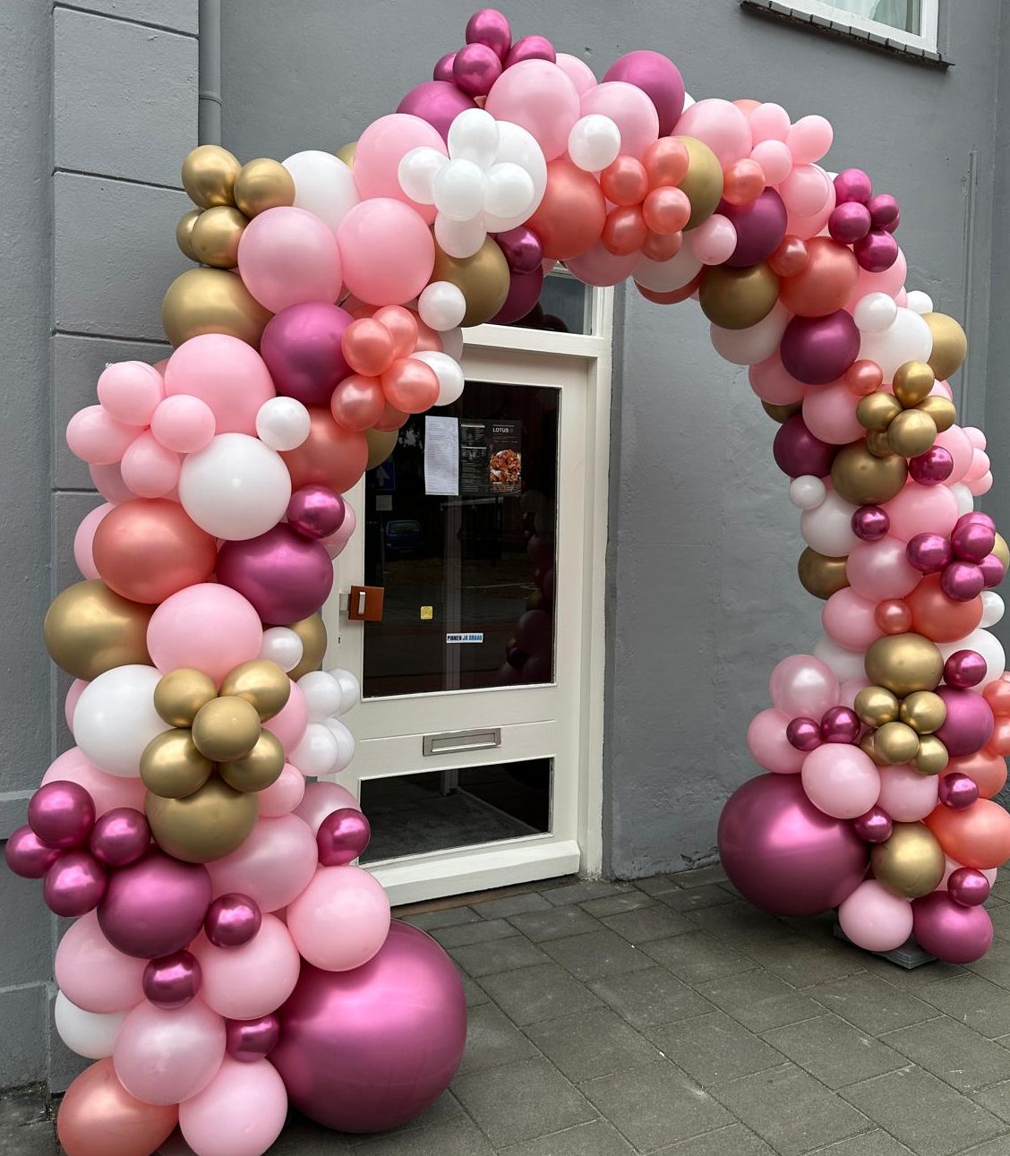 Ballonnenboog met roze, witte, gouden en paarse ballonnen