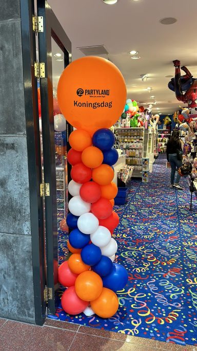 Ballonnenpilaar met rode witte blauwe en oranje ballonnen met top-ballon en tekst